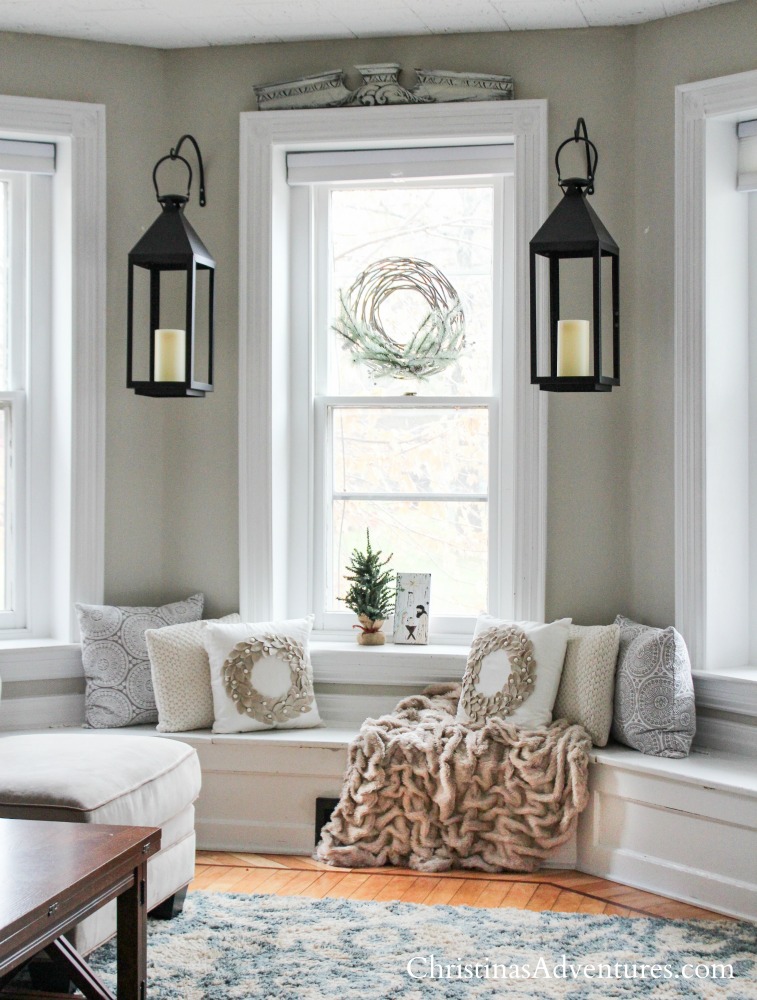 cozy neutral early Christmas decorating with textures throw pillows and throw blanket and black lanterns