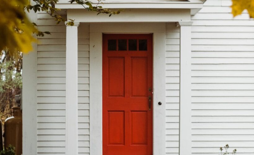 red front door with white siding