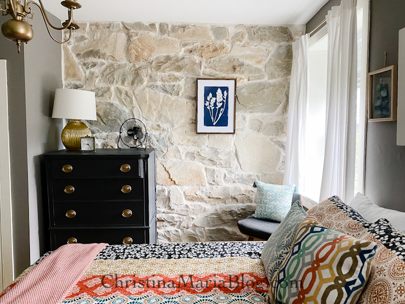 exposed stone wall black painted dresser