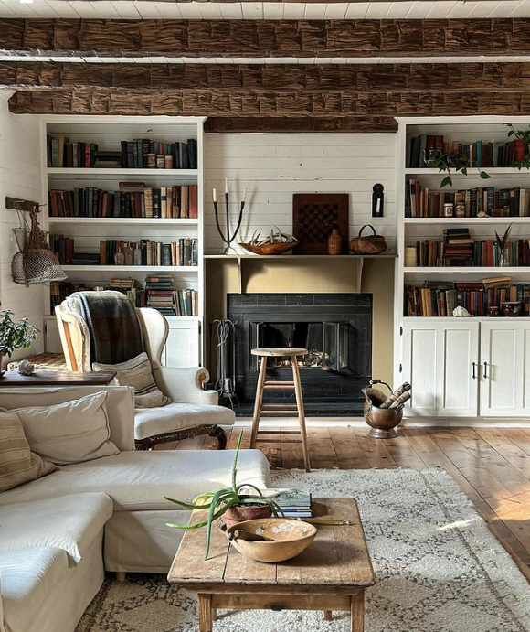 fireplace with wood beams on ceiling and built in bookcases